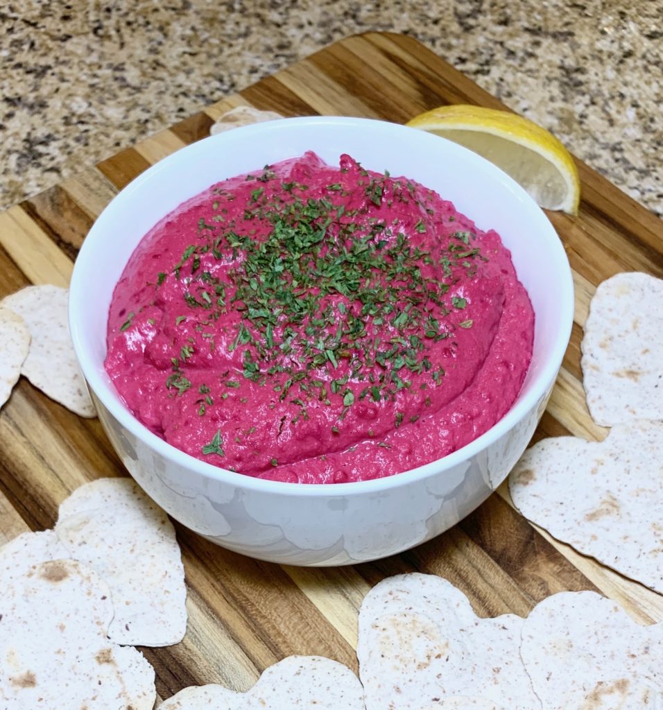 Pink Athlete Beet Hummus with heart-shaped pita chips for Valentines's Day.